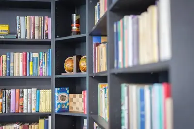 a book shelf filled with lots of books at 2022 Central Apartment Maribor (Garden + Parking) in Maribor