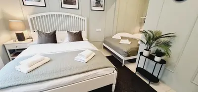a bedroom with a white bed and a chair at Cankar's cute apartment in Ljubljana