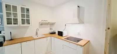 a kitchen with white cabinets and a sink at Cankar's cute apartment in Ljubljana