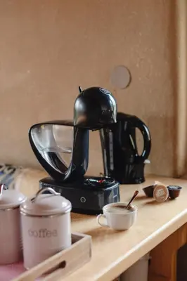 a black coffee maker sitting on a table with cups at Holiday House Clavis in Dobrovnik