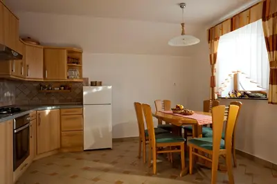 a kitchen with a table and a white refrigerator at Vineyard Cottage Ucman in Otočec