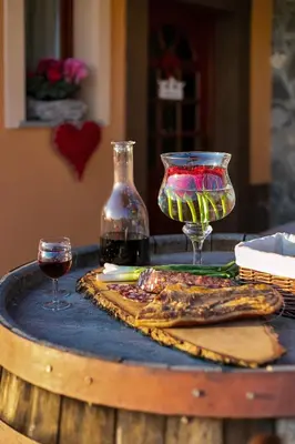 a table with two glasses of wine on a barrel at Vineyard Cottage Tramte in Škocjan