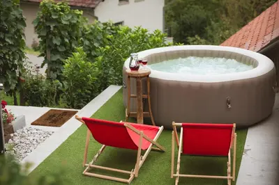 two chairs and a hot tub on a yard at Vineyard Cottage Tramte in Škocjan