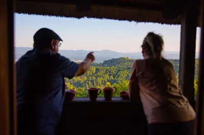 a man and a woman looking out of a window at Vineyard Cottage Skatlar in Otočec