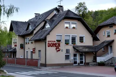 a building with a sign on the side of it at Guesthouse Zorko Gostilna Domen in Smarjeske Toplice