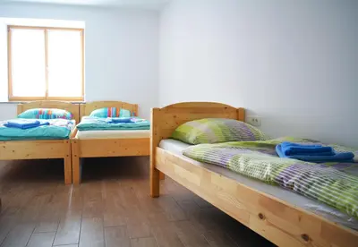 two wooden beds in a room with a window at Turistična kmetija Pri Požarju in Knežak