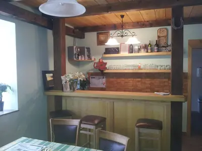a bar in a restaurant with a table and chairs at Turistična kmetija Pri Požarju in Knežak