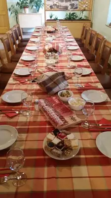 a long table with plates of food and wine glasses at Turistična kmetija Pri Požarju in Knežak