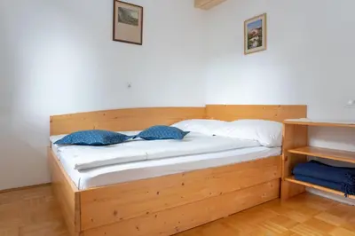 a wooden bed with two pillows on it in a room at Apartments Maja by the river in Bohinj