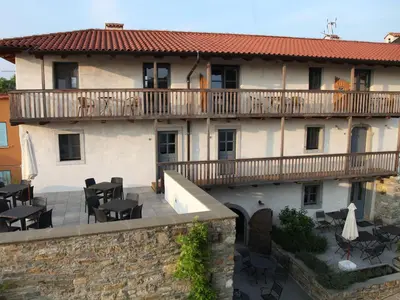 a building with a balcony with tables and chairs at Boutique Hotel Dvor in Dobrovo