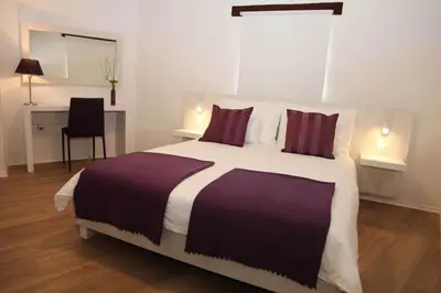 a bedroom with a large bed and a desk at Boutique Hotel Dvor in Dobrovo