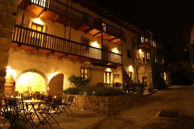 a building with tables and chairs outside at night at Boutique Hotel Dvor in Dobrovo