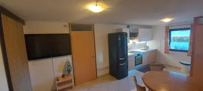a kitchen with a dining room table and a black refrigerator at Apartments Lenardic in Bled