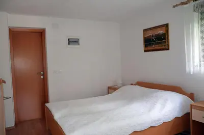 a bedroom with a white bed and a window at Apartments Lenardic in Bled