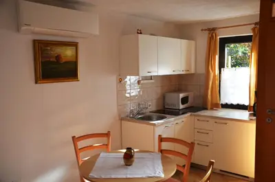 a small kitchen with a table and a sink at Apartments Lenardic in Bled
