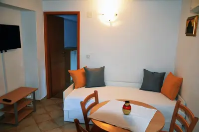 a small room with two beds and a table at Apartments Lenardic in Bled