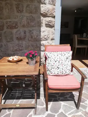 a chair with a pillow sitting next to a table at Apartments Mas in Dovje