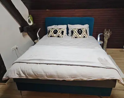 a bed with a blue headboard and pillows at Soba 7 Pekrska vila in Limbuš