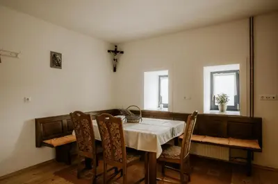 a dining room with a table and chairs and two windows at Vineyard Cottage Zdolsek in Šmarje pri Jelšah