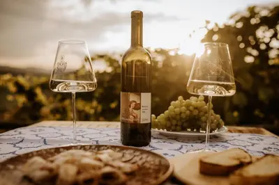 a table with two wine glasses and a plate of grapes at Vineyard Cottage Zdolsek in Šmarje pri Jelšah