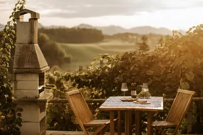 a table with two chairs and a glass of wine at Vineyard Cottage Zdolsek in Šmarje pri Jelšah