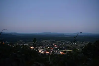 a view of a town from a hill at dusk at Vineyard Cottage Zajc in Semič