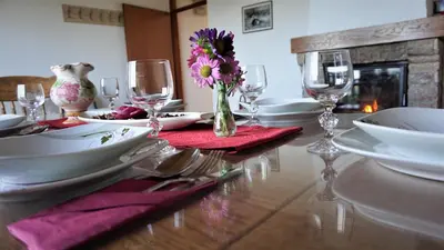 a table with plates and glasses and a vase of flowers at Vineyard Cottage Zajc in Semič