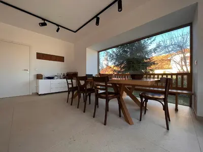 a dining room with a table and chairs and a large window at Villa Boris in Starše
