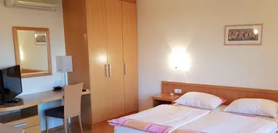 a bedroom with a bed and a desk with a computer at Apartments AD Radenci in Radenci