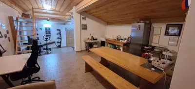 a kitchen with a wooden table and a refrigerator at Prenočišče pri Sodarju in Beltinci