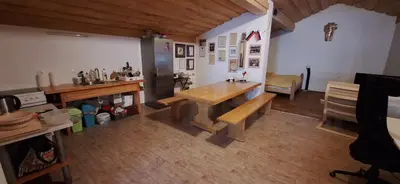 a kitchen with a wooden table in a room at Prenočišče pri Sodarju in Beltinci