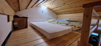 a bedroom with a bed in a wooden room at Prenočišče pri Sodarju in Beltinci