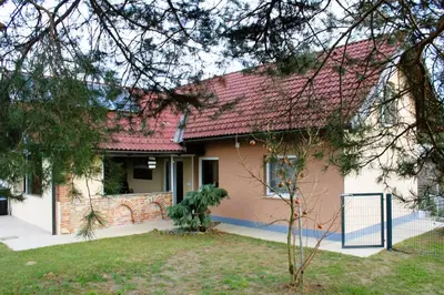 a house with a red roof and a yard at POČITNIŠKA HIŠA SONČNI VRH in Spodnji Ivanjci