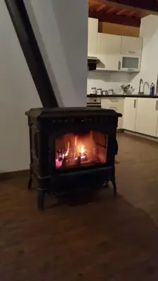 a stove in a kitchen with a fire in it at POČITNIŠKA HIŠA SONČNI VRH in Spodnji Ivanjci