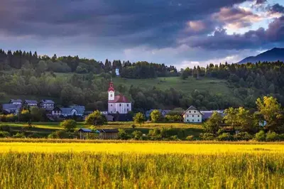 a small town in the hills with a yellow field at Tiny Bled house in Bled