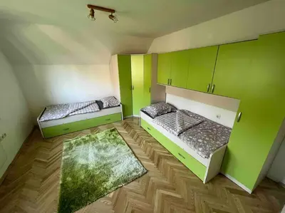 two beds in a room with green walls at Tiny Bled house in Bled