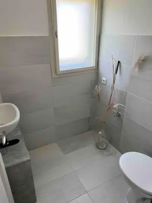 a bathroom with a sink and a toilet and a window at Tiny Bled house in Bled