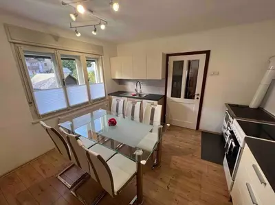 a kitchen with a glass table and chairs and a stove at Tiny Bled house in Bled