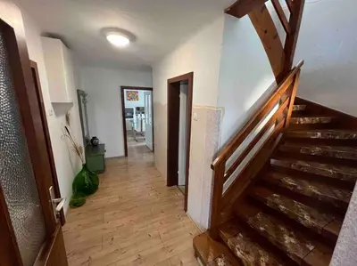 a hallway with a wooden staircase in a house at Tiny Bled house in Bled
