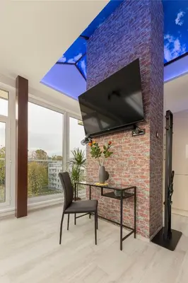 a living room with a brick wall with a flat screen tv at Luiza's Apartment in Ljubljana