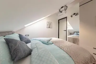 a bedroom with two beds with blue pillows at Luiza's Apartment in Ljubljana