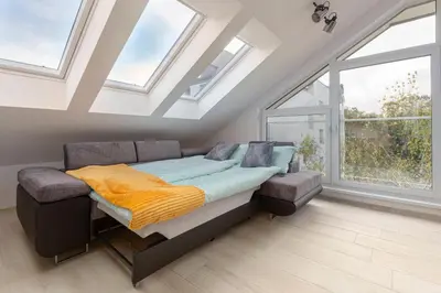 a bedroom with a bed in a room with skylights at Luiza's Apartment in Ljubljana