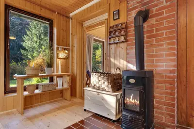 a fireplace in a room with a brick wall at Cabin by the river Polhov Gradec in Polhov Gradec