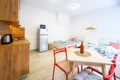 a kitchen with a table and a kitchen with two beds at The Urban Loft in Ljubljana