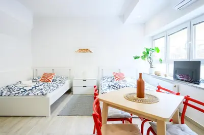 a bedroom with two beds and a table and chairs at The Urban Loft in Ljubljana
