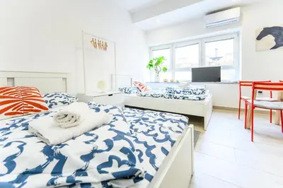 a bedroom with two beds with blue and white sheets at The Urban Loft in Ljubljana