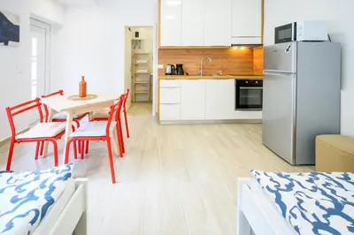 a kitchen and dining room with a table and a refrigerator at The Urban Loft in Ljubljana