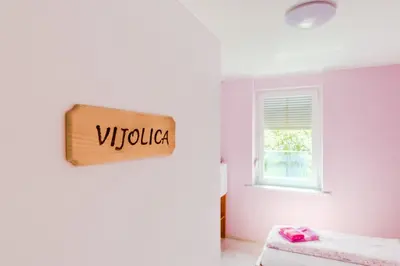 a bedroom with a sign that reads virka on the wall at Apartments Orhideja in Tolmin