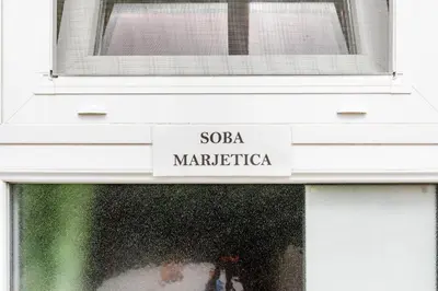 a window with a sign that reads soa maraterica at Apartments Orhideja in Tolmin