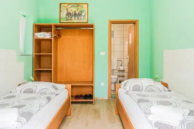 two beds in a room with green walls at Apartments Orhideja in Tolmin